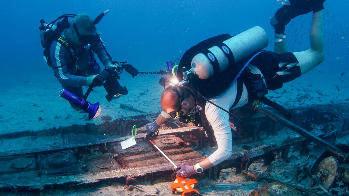 Underwater divers inspect crash site.
